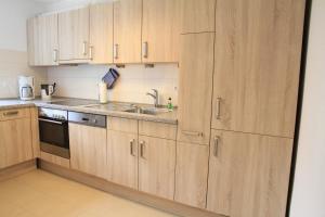 a kitchen with wooden cabinets and a sink at Comfort Lodging Stueckenfeld in Hannover