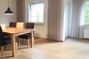 een eetkamer met een houten tafel en stoelen bij Comfort Lodging Stueckenfeld in Hannover +39 foto's