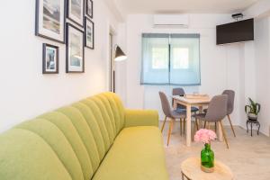 een woonkamer met een gele bank en een tafel bij Apartments History in Split