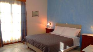 a bedroom with a bed and a blue wall at Vaporia in Ermoupoli