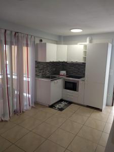 eine Küche mit weißen Schränken und einem Fliesenboden in der Unterkunft Casa Laura Vivienda Vacacional in Los Cristianos