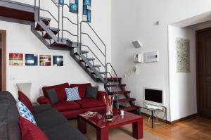 a living room with a red couch and a staircase at Fancy Blue Duomo Duplex Apartement in Milan