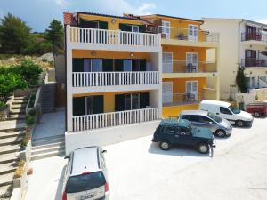 an apartment building with cars parked in a parking lot at Sea View Luxury Apartments, ALA DA in Milna