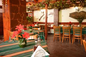 a restaurant with tables and chairs with flowers on them at Park Hotel Ribaritsa in Ribarica