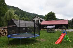 a playground with a trampoline in the yard at Cabana Steaua Nordului 2 in Vînători