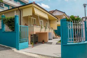 een huis met blauwe poorten ervoor bij Ariadnes Apartments in Tirana