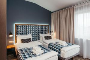 a hotel room with two beds with towels on them at Avena Boutique Hotel by Artery Hotels in Krakow