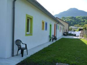Deux chaises assises sur le côté d'une maison dans l'établissement Residence Bed&Bike, à Moggio Udinese