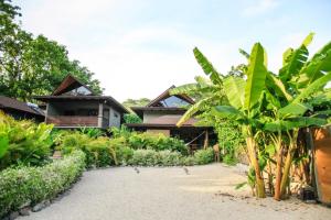 a house with a bunch of trees in front of it at Lua Villas in Santa Teresa Beach