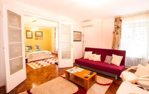 a living room with a red couch and a bed at B Apartments - Apartment Bastion in Timişoara