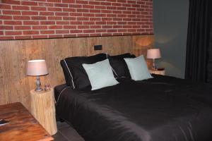 a bedroom with a black bed with two lamps at B & B Chawe in Enschede
