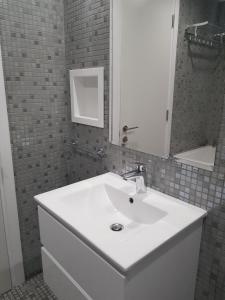a bathroom with a white sink and a mirror at Yialos Holiday Apartments in Pervolia +46 photos