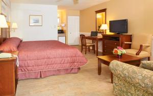 Habitación de hotel con cama y sala de estar. en Stockton Inns en Cape May
