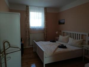 1 dormitorio con 1 cama blanca y ventana en Ferienwohnung am Torbogen Nr.2, en Lübbenau
