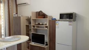 a kitchen with a white refrigerator and a microwave at Studio Morski Briz in Burgas City