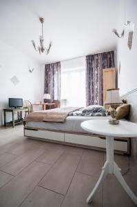 a bedroom with a bed and a table and a window at Apartment Bugaj in Warsaw