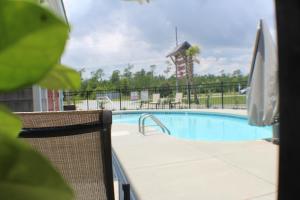 einen Pool in einem Resort mit Stühlen und einer Wasserrutsche in der Unterkunft Topsail Shores Inn in Sneads Ferry