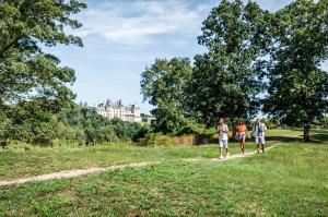 a group of three people walking down a path in a field at Village Hotel on Biltmore Estate in Asheville
