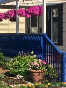 a blue fence with flowers in front of a house at Ellis House Bed & Breakfast in Niagara Falls