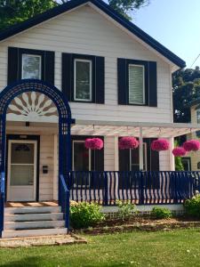 uma casa com um portão azul e flores cor-de-rosa em Ellis House Bed & Breakfast em Cataratas do Niágara