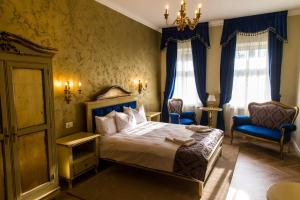 a bedroom with a bed and two chairs and a chandelier at Artisans Boutique Villa in Sibiu