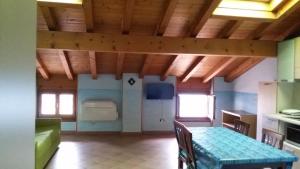 una sala da pranzo con tavolo e una cucina di Mansarda Ariel a Limone sul Garda