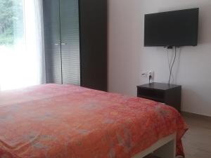 a bedroom with a bed and a flat screen tv at Apartman Put in Baška