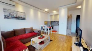 una sala de estar con un sofá y una mesa en Piano Apartments Delta City, en Podgorica