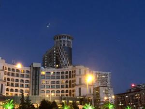 a tall building in a city at night at Orbi Sea Towers Batumi in Batumi