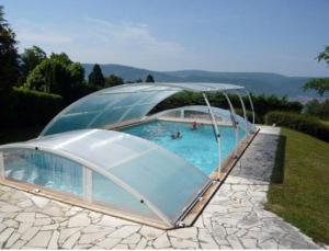 a large swimming pool with a domed roof at Chambres d'Hôtes Baudelys in Pont-de-Larn
