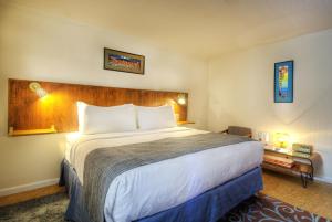 a hotel room with a large bed and a desk at Roadrunner Lodge Motel in Tucumcari +20 photos