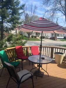 a table with chairs and an umbrella on a deck at Ellis House Bed & Breakfast in Niagara Falls