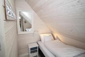 una casa pequeña con cama y espejo en Baltic Sky, en Pobierowo