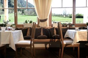 a dining room with two tables and a couch at Chalet Rasteck in Campo Tures