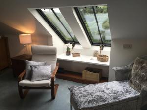 a attic living room with a chair and a window at The Suite at Scarbuie in Ballater
