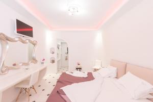 a bedroom with a white bed and white walls at Anezina Villas in Perissa