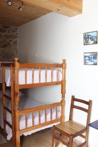 ノアリャにあるA Casiña de Pedraの二段ベッド2台と椅子が備わる客室です。