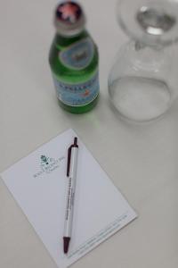 un bolígrafo en un papel junto a una botella de soda en Rogue Regency Inn & Suites, en Medford