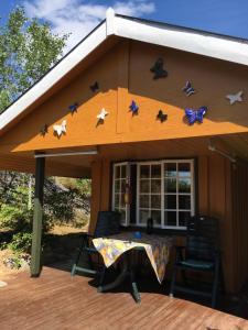 a house with a table and chairs on a deck at The Yellow House in Bamble