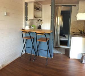 a tiny kitchen with a counter and two stools at The Yellow House in Bamble