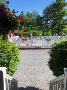 a white fence in front of a swimming pool at Lyn Aire Motel - Lake George in Lake George