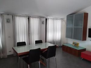 Cette chambre comprend une table, des chaises et des rideaux. dans l'établissement La casa di Gio, à Varazze
