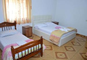 a bedroom with two beds and two tables and windows at Apartments Beti in Ulcinj