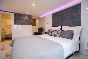 a bedroom with a large white bed and a bathroom at Soleil Luxury Rooms Old town in Dubrovnik