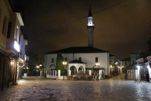 une église la nuit avec une tour dans une rue dans l'établissement Hotel Old Konak, à Skopje