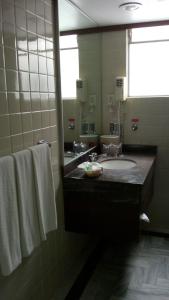 a bathroom with a sink and a mirror and towels at Segovia Regency in Mexico City