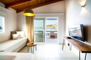 een woonkamer met een bank en een televisie bij Sunrise Apartments in Agia Pelagia