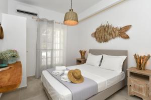 a bedroom with a bed with a hat on it at Corina Studios-Apartments in Naousa +95 photos