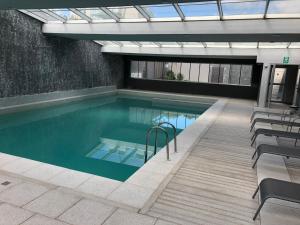 a swimming pool with chairs in a building at Look Brava 2103 in Punta del Este