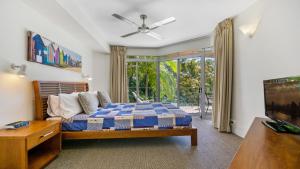 a bedroom with a bed and a large window at Park Cove Apartments in Noosa Heads